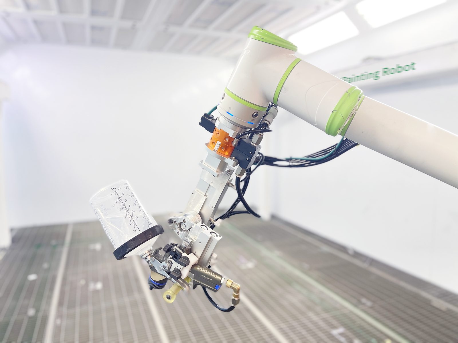 Close-up of the spray applicator and paint cup on the robot's wrist